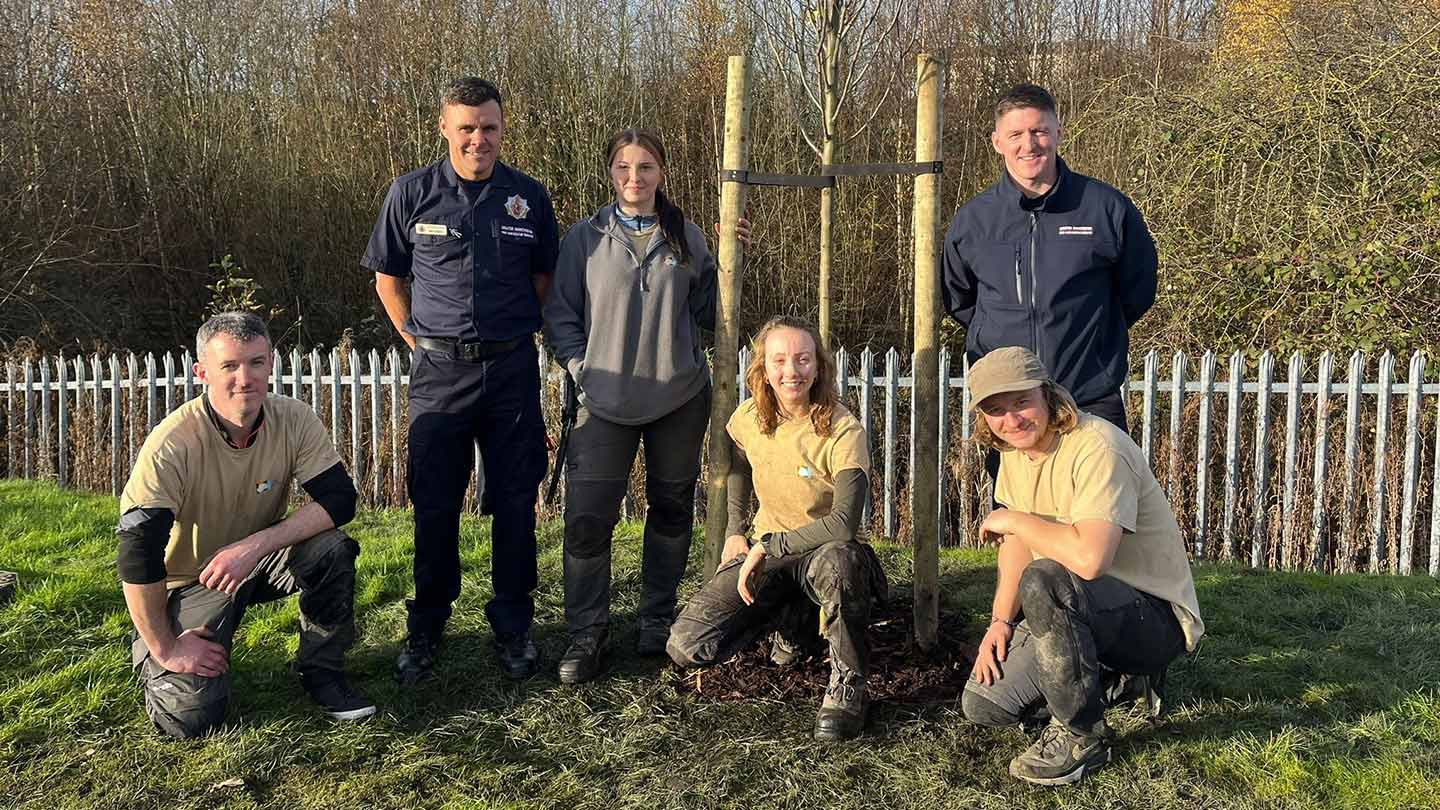 Six members of the City of Trees' contractor team posing for photo with new tree.